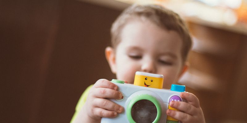 Bambino che tiene in mano una macchina fotografica giocattolo